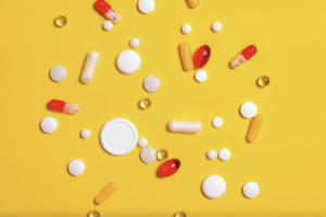 Vitamin B capsules and pills on a yellow surface