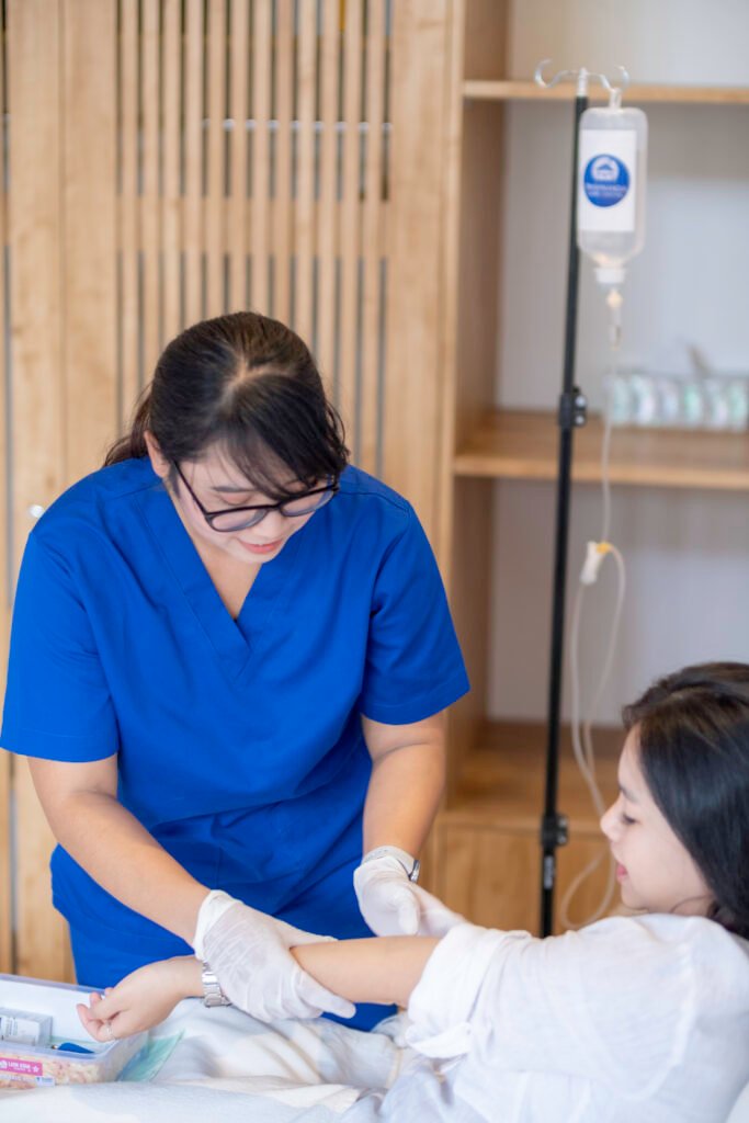 Trishnanda nurse treating a guest in bed with IV therapy at villa in Bali