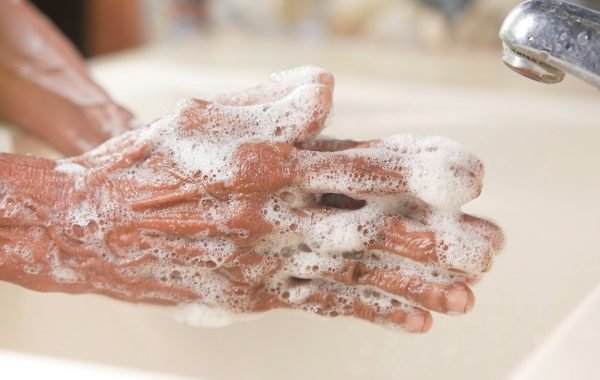 Washing hands thoroughly with soap and clean water